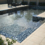 Jeffrey Court Pool Mosaic installed in a swimming pool surrounded by porcelain pavers