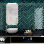 Zellige Forest 3x12 Glossy Ceramic Subway tile installed as a herringbone in a counter to ceiling backsplash behind a vanity with a vessel sink